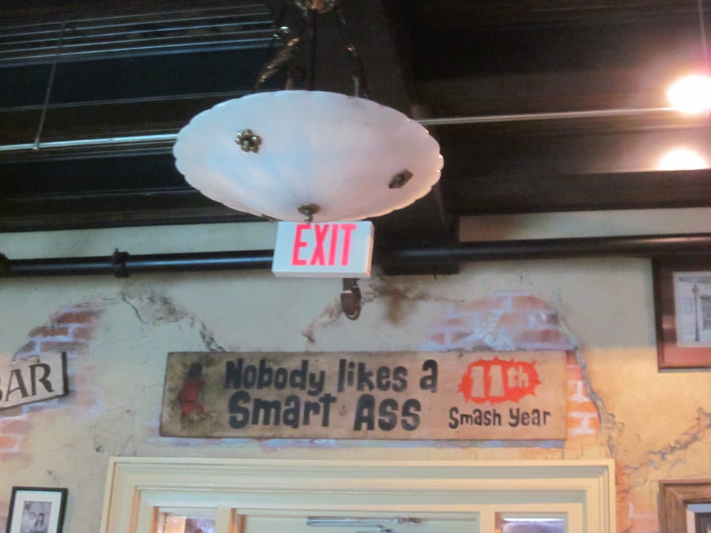 Bar sign that reads "Nobody Likes a Smart Ass"