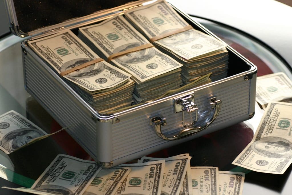 A lockbox filled with one hundred dollar bills.