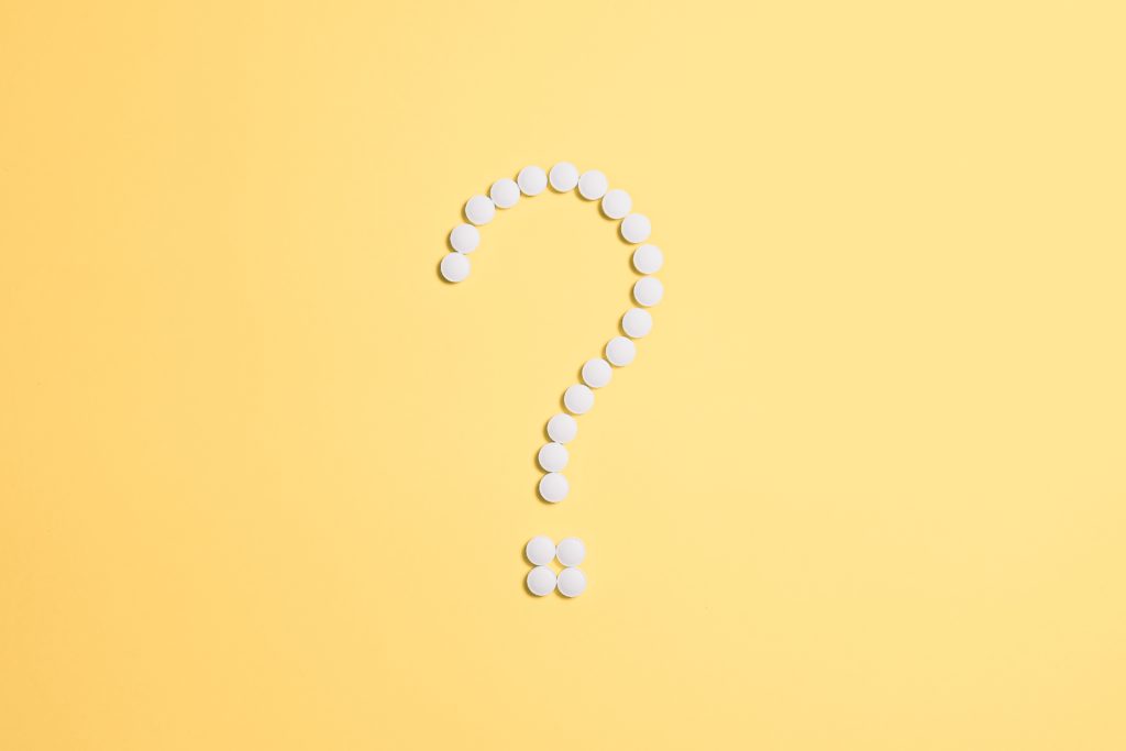 White buttons creating a question mark against a yellow background