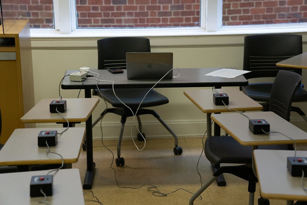 Desks in a room with buzzers on each one.