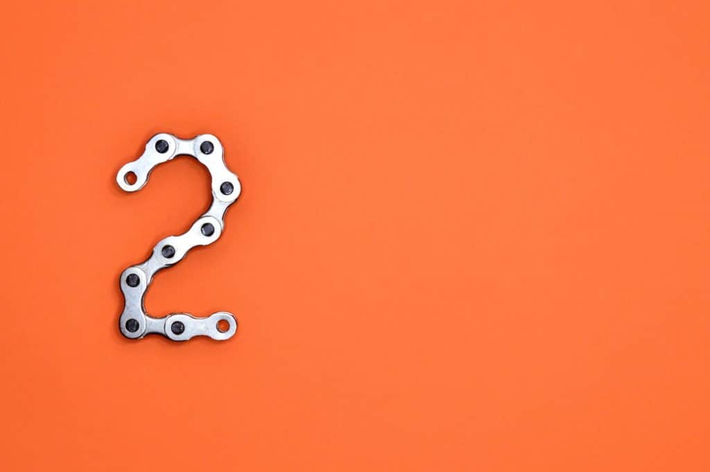 Metal clamps spelling out the number "2" against an orange background