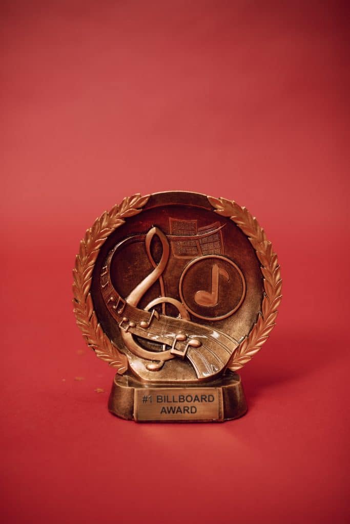 A gold Billboard award against a red background