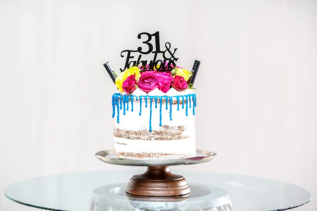 A birthday cake with a topper that says "31 & Fabulous"
