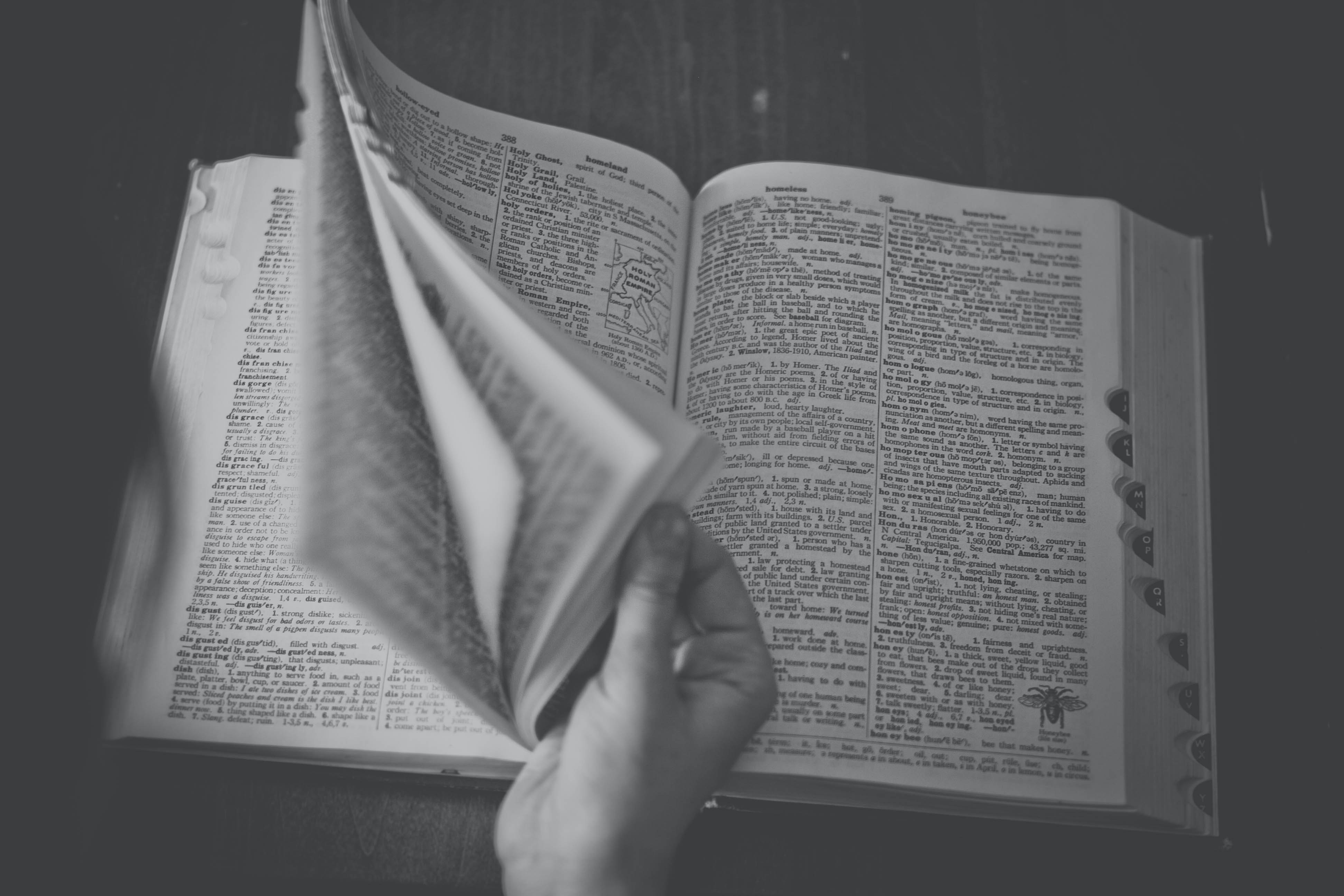 Black and white photo of someone flipping through a dictionary