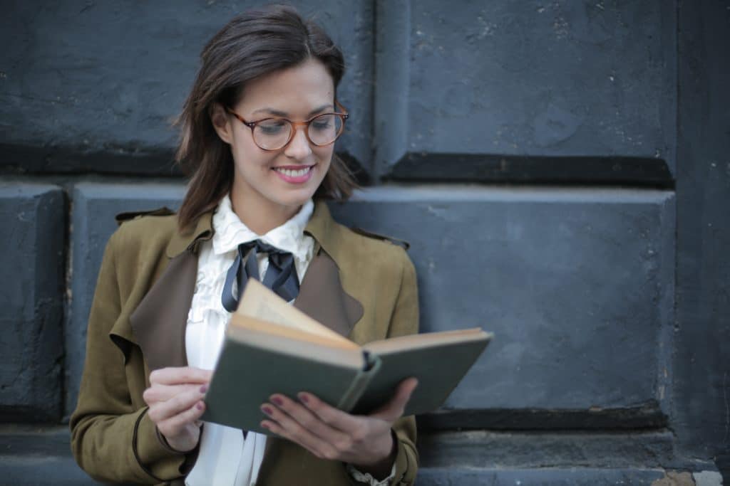 Professional looking woman with glasses reading a book