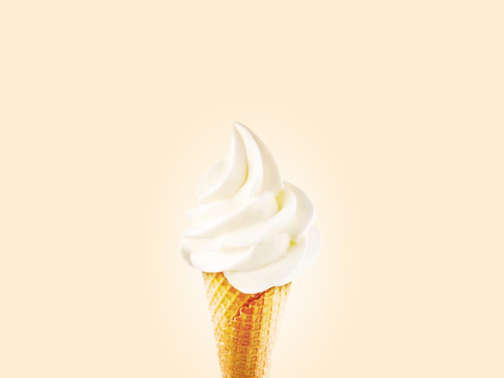 Vanilla ice cream cone against a yellow background