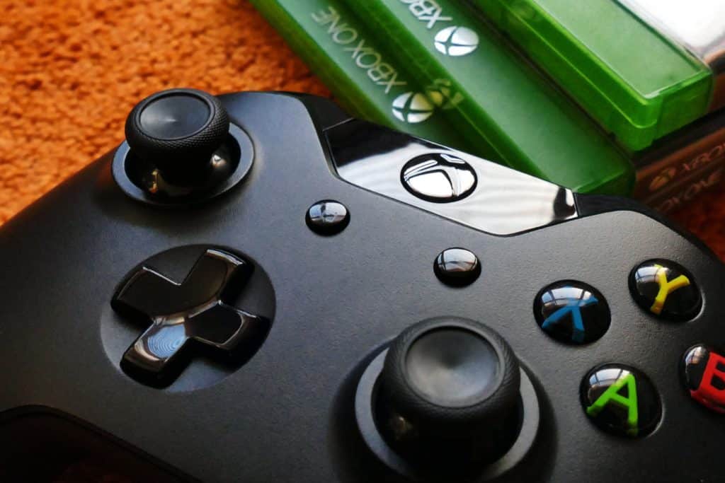 Close up of an Xbox controller next to a stack of Xbox games