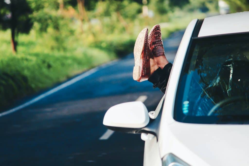 A person sticking their feet out a car window