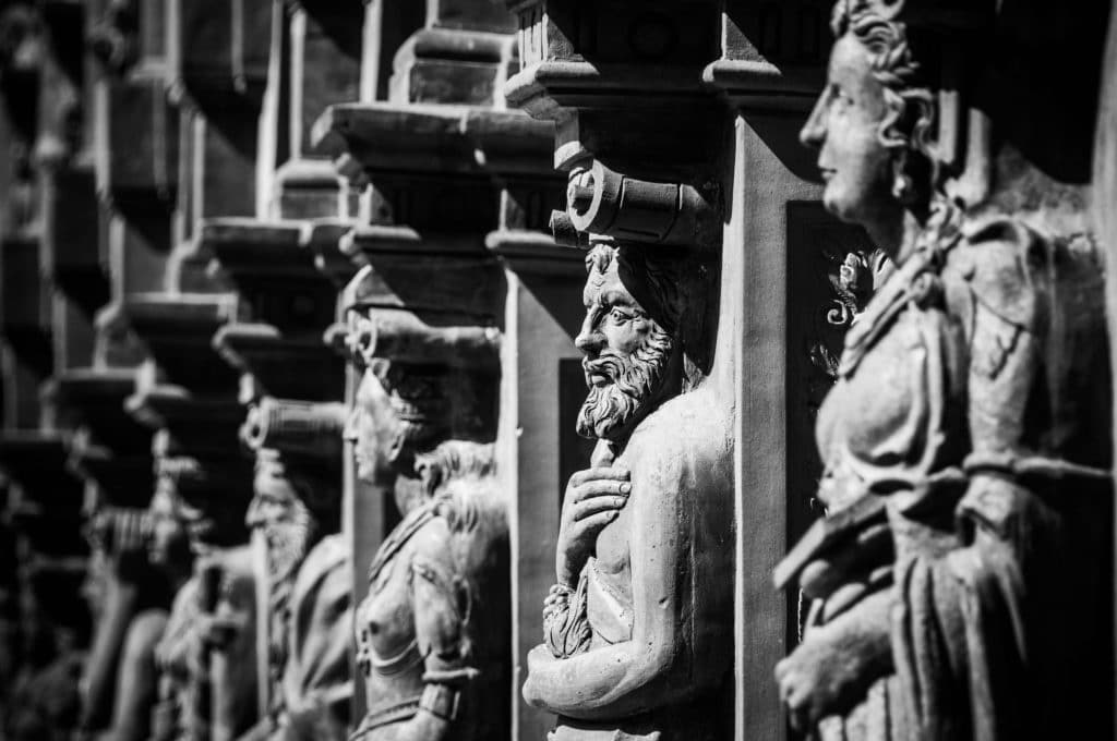 Grayscale photo of Roman statues and columns