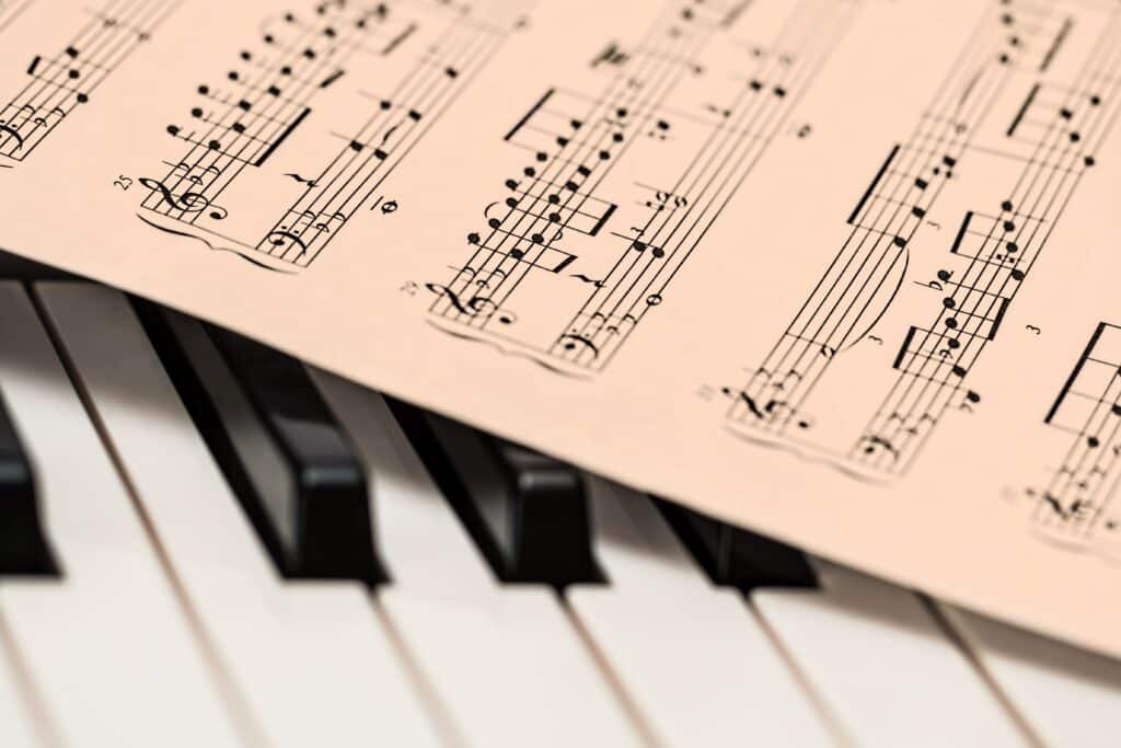 A sheet of music notes atop piano keys