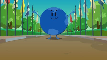Tito, the blue globe character, from Netflix's Trivia Quest. Tito is standing, arms outstretched, on a path flanked by numerous flags from around the world. 