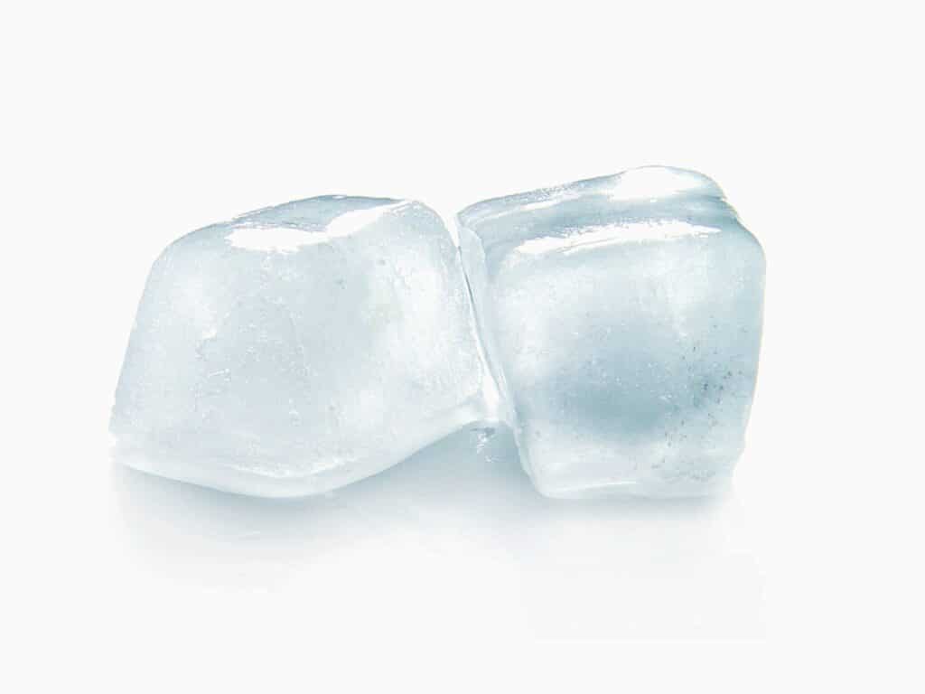 Close up of two ice cubes against a white background