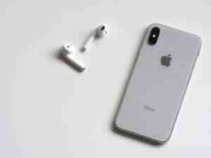 Photo of a white iPhone and airpods against a white background