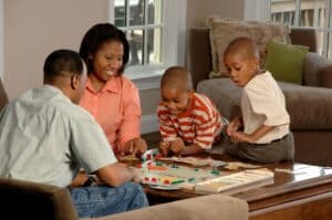 A husband, wife and two sons gathered around a board game