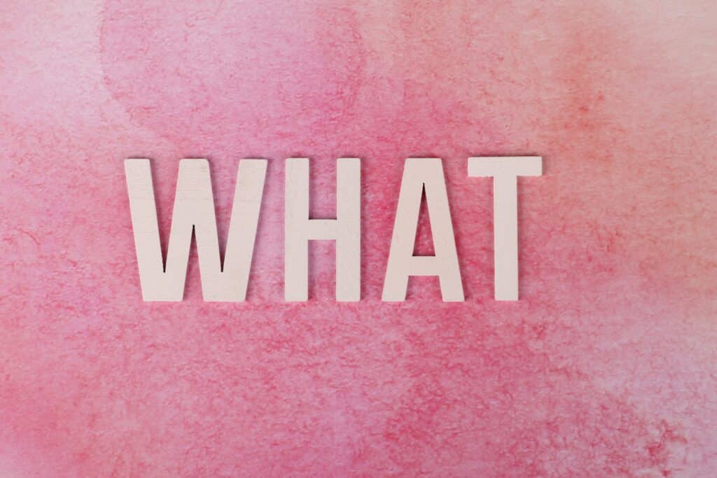 The word WHAT in white letters against a pink background