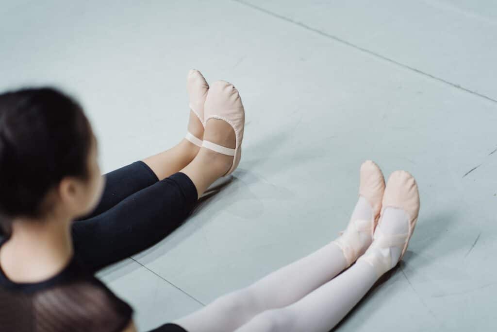 Photo of two ballerinas' legs sitting next to each other