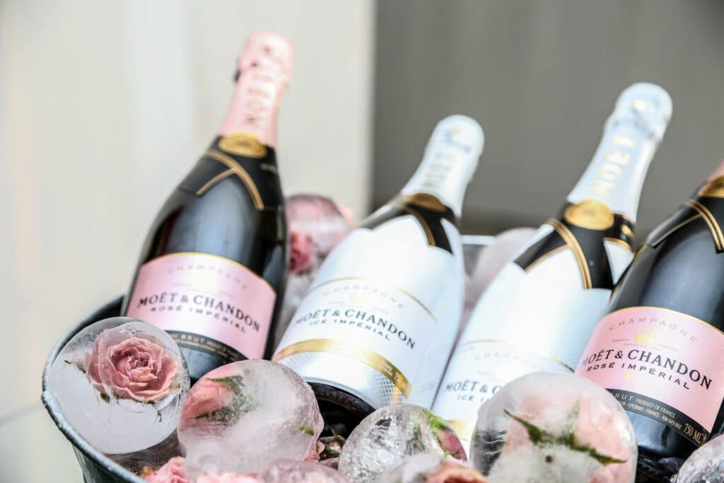 A bucket of different bottles if champagne with roses frozen in ice