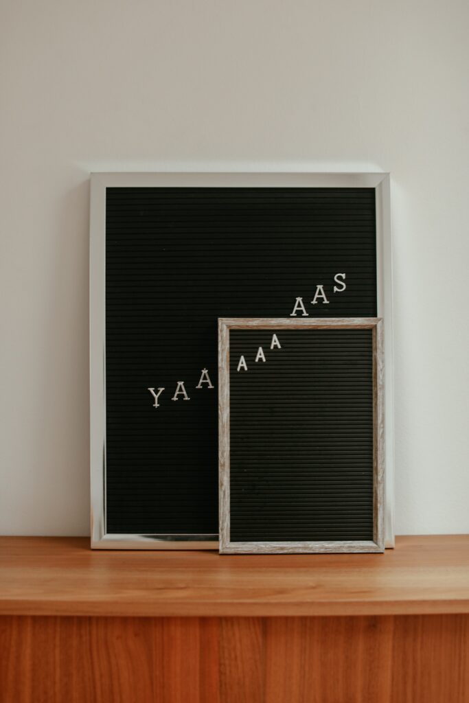 Black wooden board with YAAAAAAAAS in white letters on it