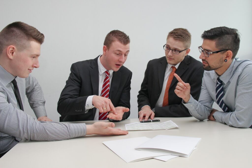 A group of four men in business clothes having a heated conversation