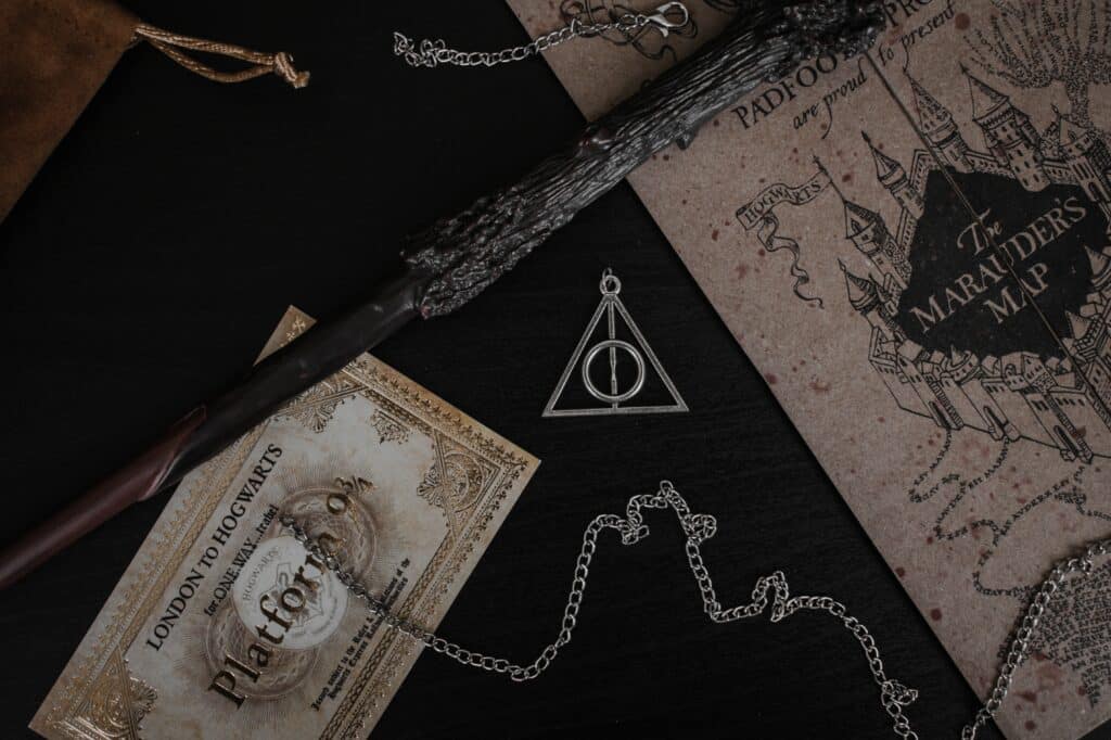 Harry Potter's wand on top of the Marauder's Map and a ticket to Platform 9 3/4
