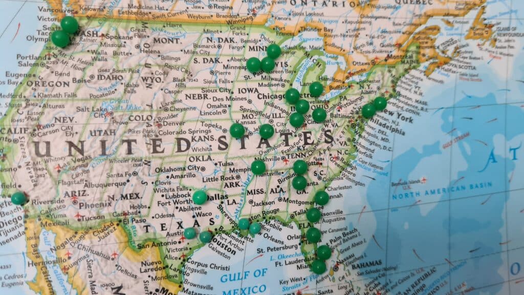 Map of the United States with green push pins on it
