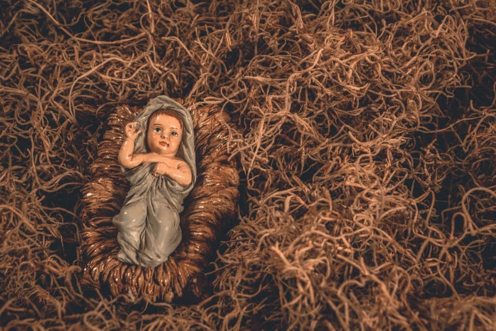 Photo of a statue of baby Jesus on hay in a manager
