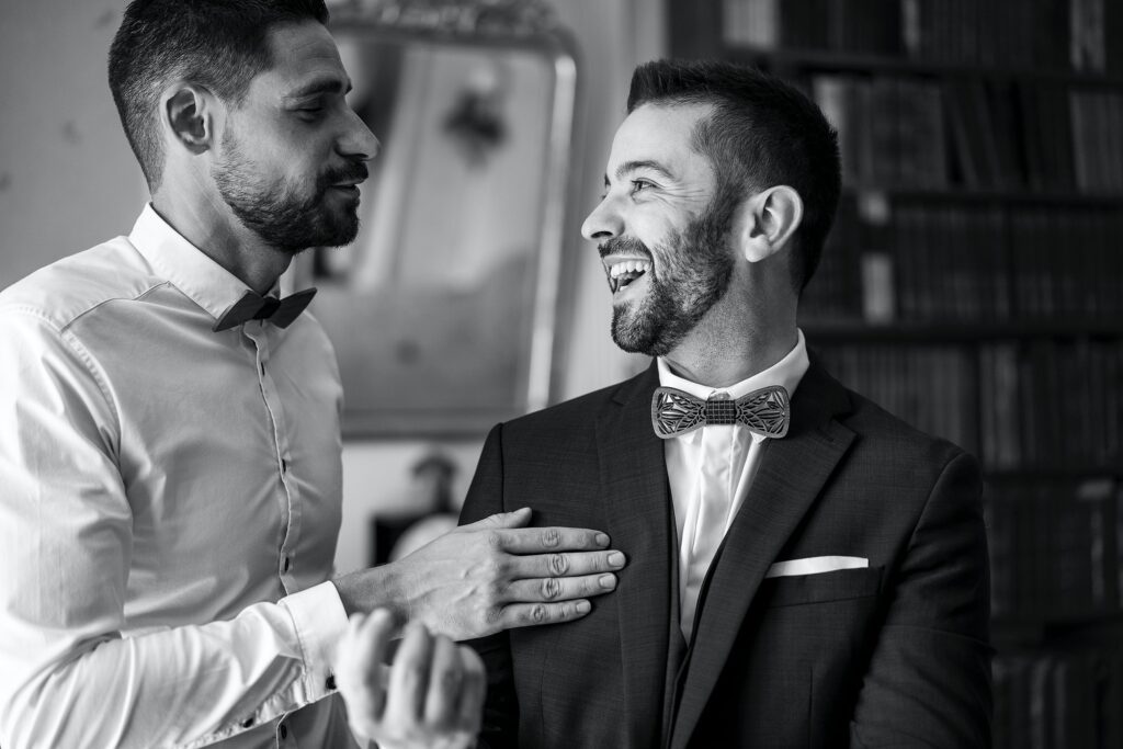 Black and white photo of two well-dresed men talking and laughing
