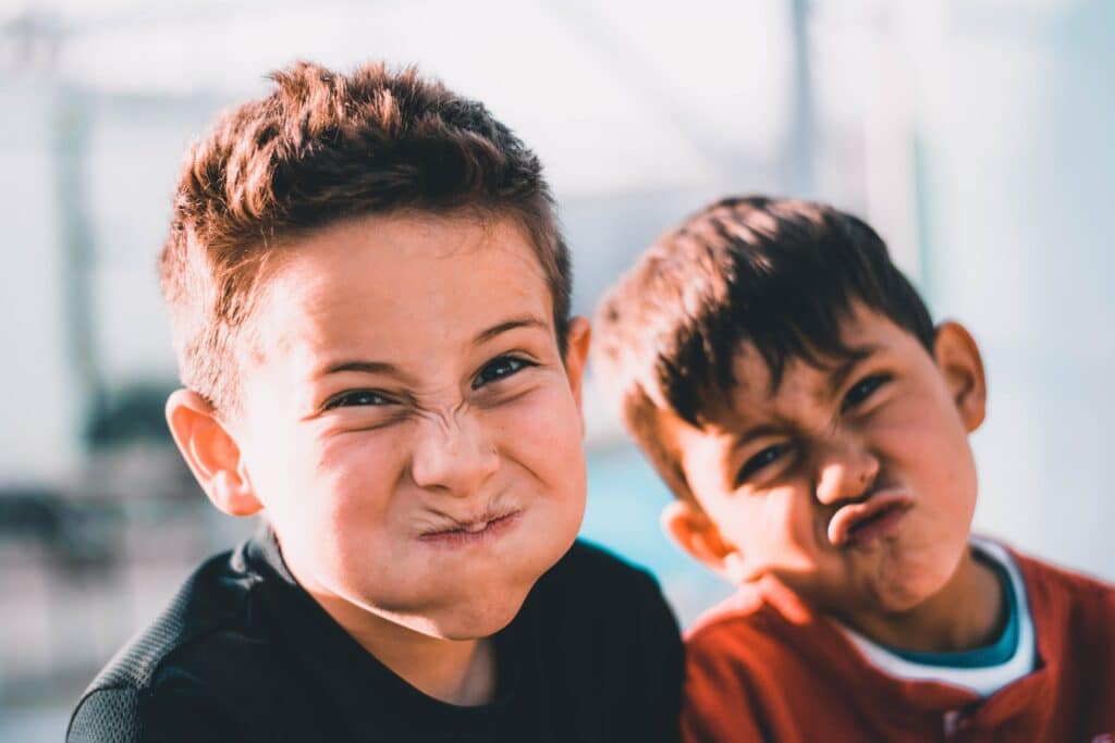 Photo of two young boys making funny, scrunched-up faces