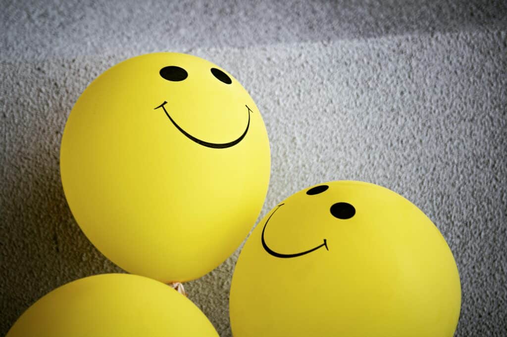 Photo of three yellow smiley face balloons