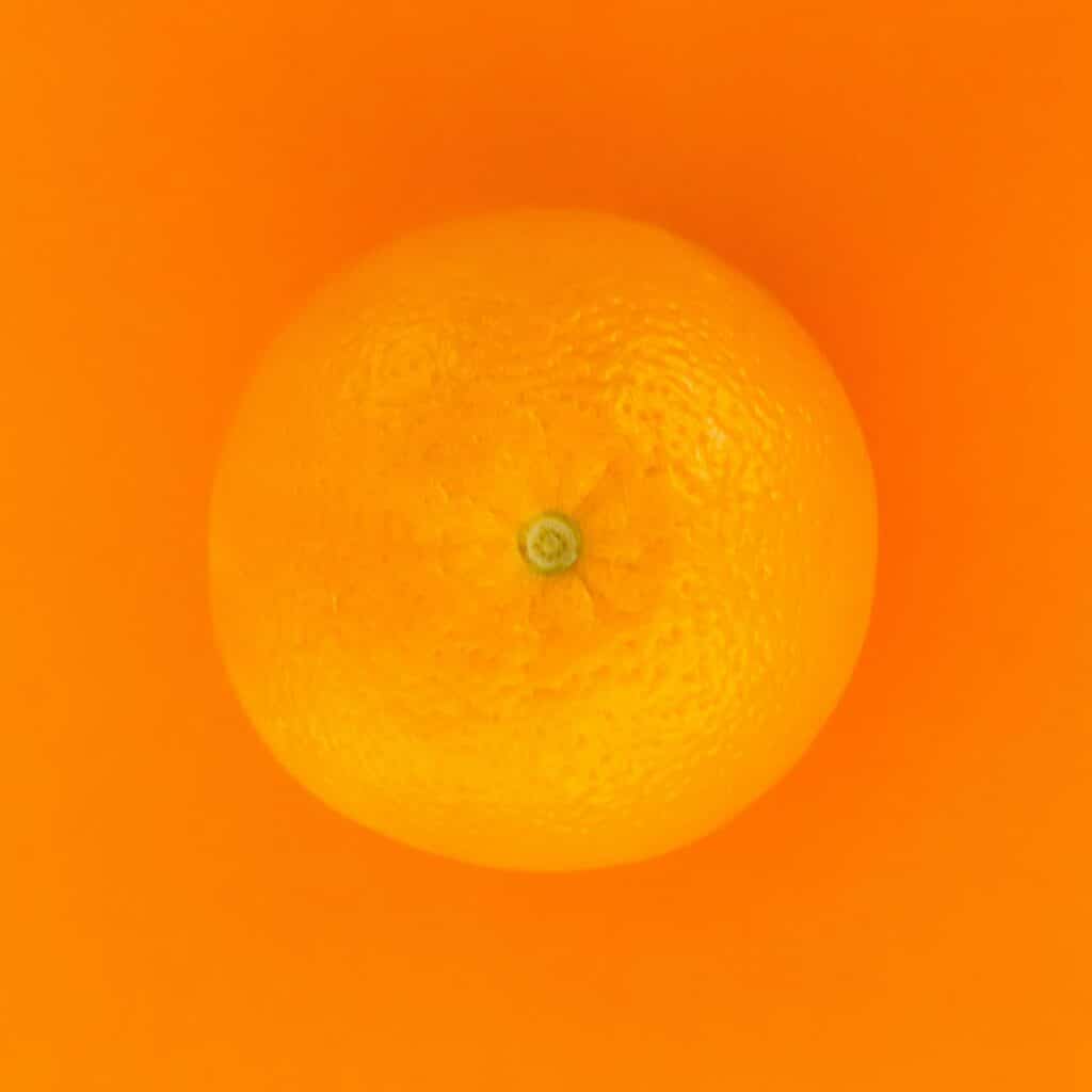 Photo of an orange against a darker orange background