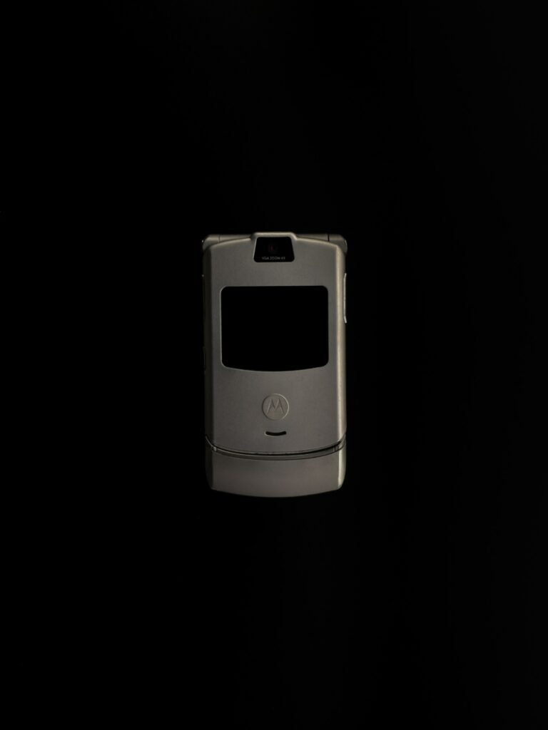 Photo of a dark grey Razr flip phone against a black background.