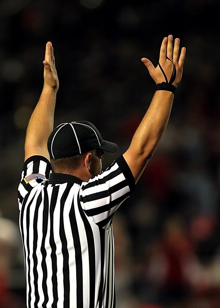 A football referee indicating that a touchdown has been made