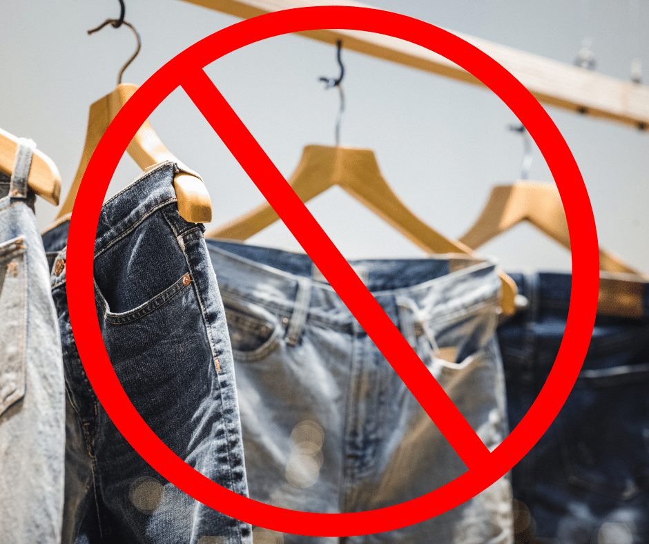 A photo of jeans on wooden hangers with a red "No" symbol atop it.