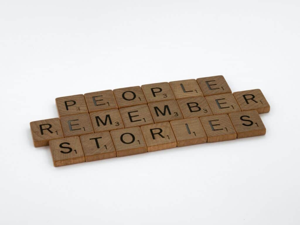 Brown wooden Scrabble blocks spelling out the phrase "People remember stories"