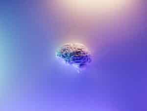 Photo of a glowing brain against a pink and blue background