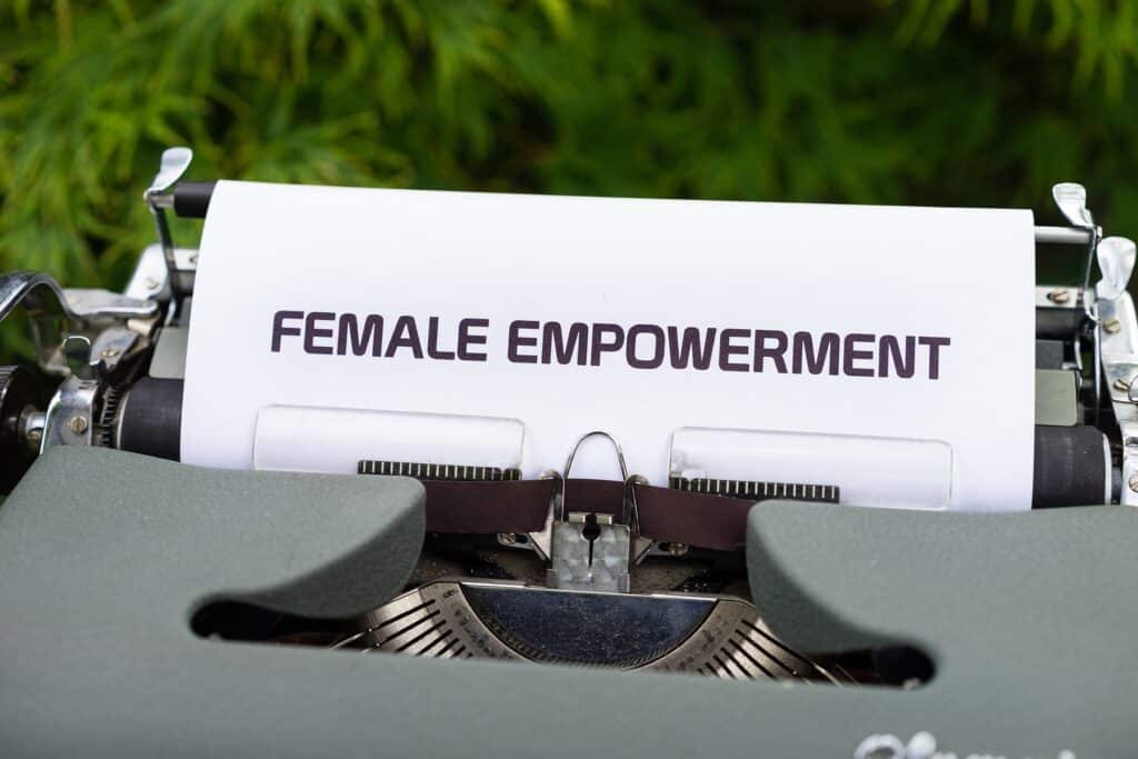 Photo of a grey typewriter with a piece of white paper in it that reads "FEMALE EMPOWERMENT"