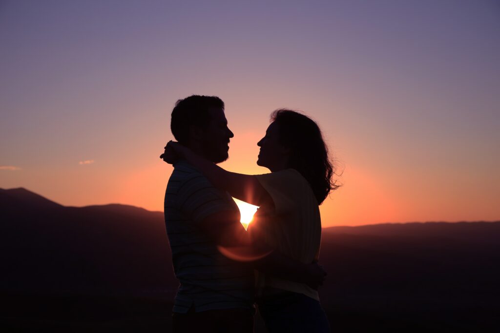 Silhouette of a couple in an embrace against the sunset.