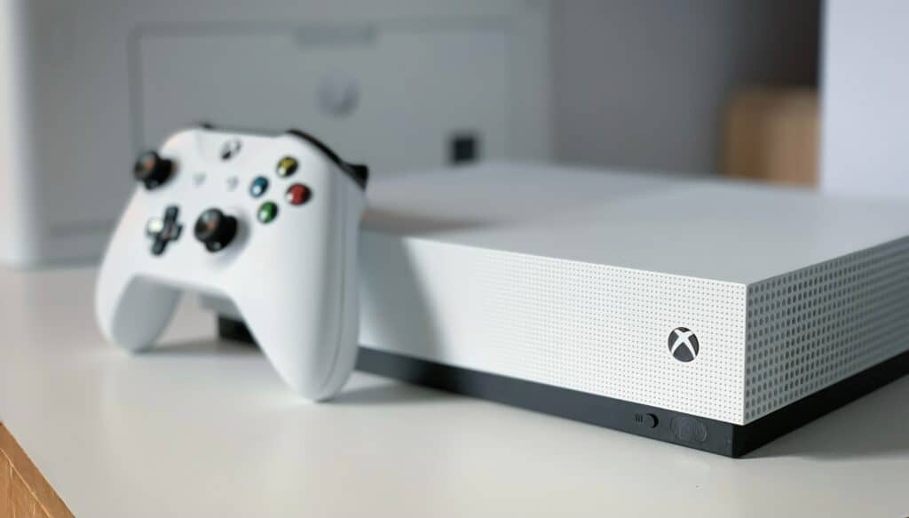 Close up photo of a white Xbox Series One with a controller leaning against it