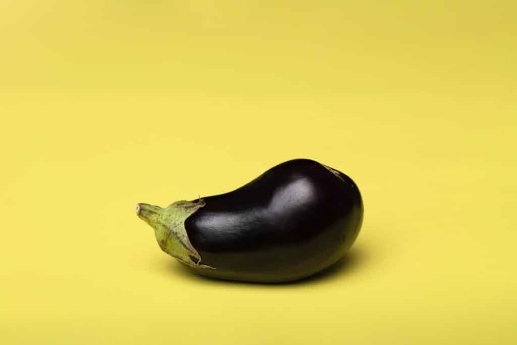 Picture of an eggplant against a yellow background.