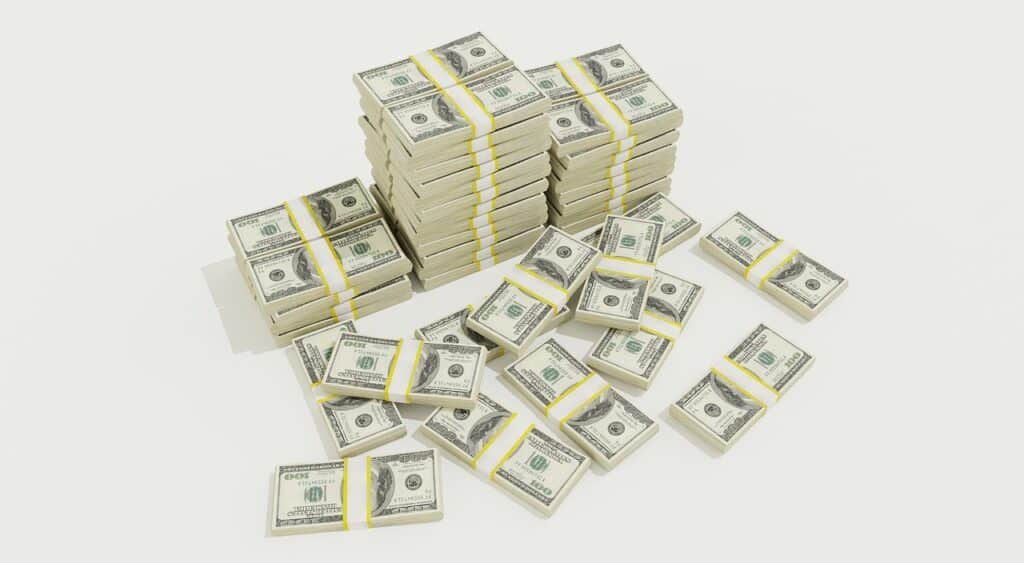 Photo of stacks of $100 bills against an off-white background.