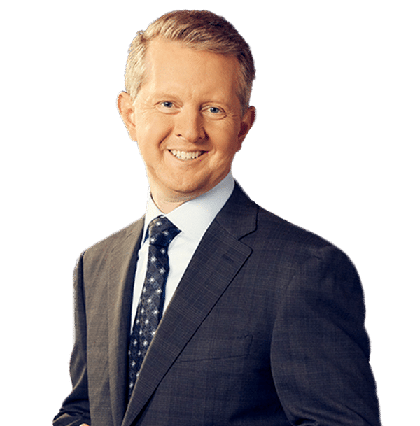 Photo of Ken Jennings in a suit and tie against a white backdrop. 