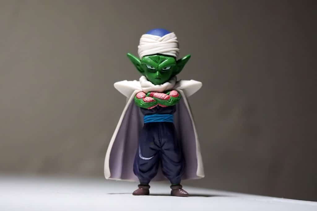 Action figure of Piccolo from Dragon Ball Z in a power position, against a beige background. 