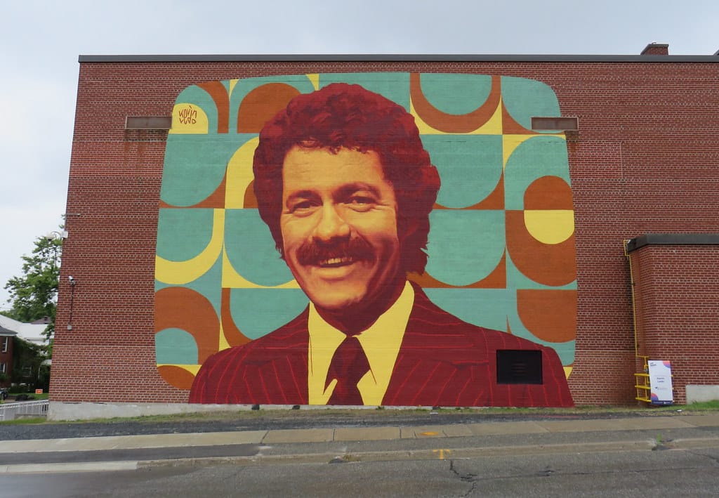 Photo of a colorful mural of Alex Trebek on a brick wall in Sudberry, CT.