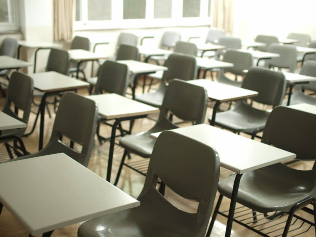Photo of many empty desks in a classroom.
