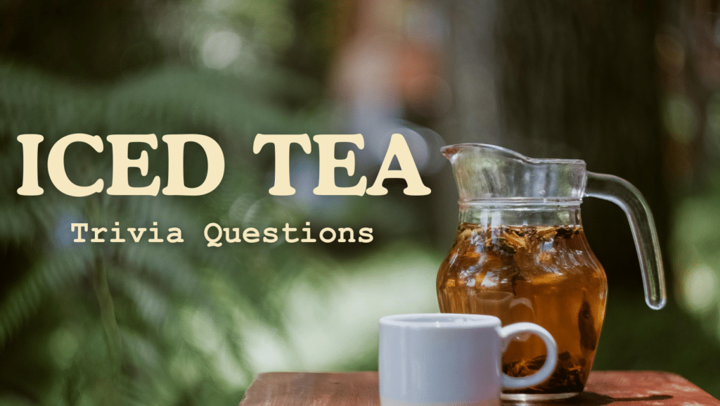 Photo of a glass pitcher of iced tea next to a white mug on a wooden table, with greenery blurred in the background. Yellow text atop it reads "ICED TEA Trivia Questions"