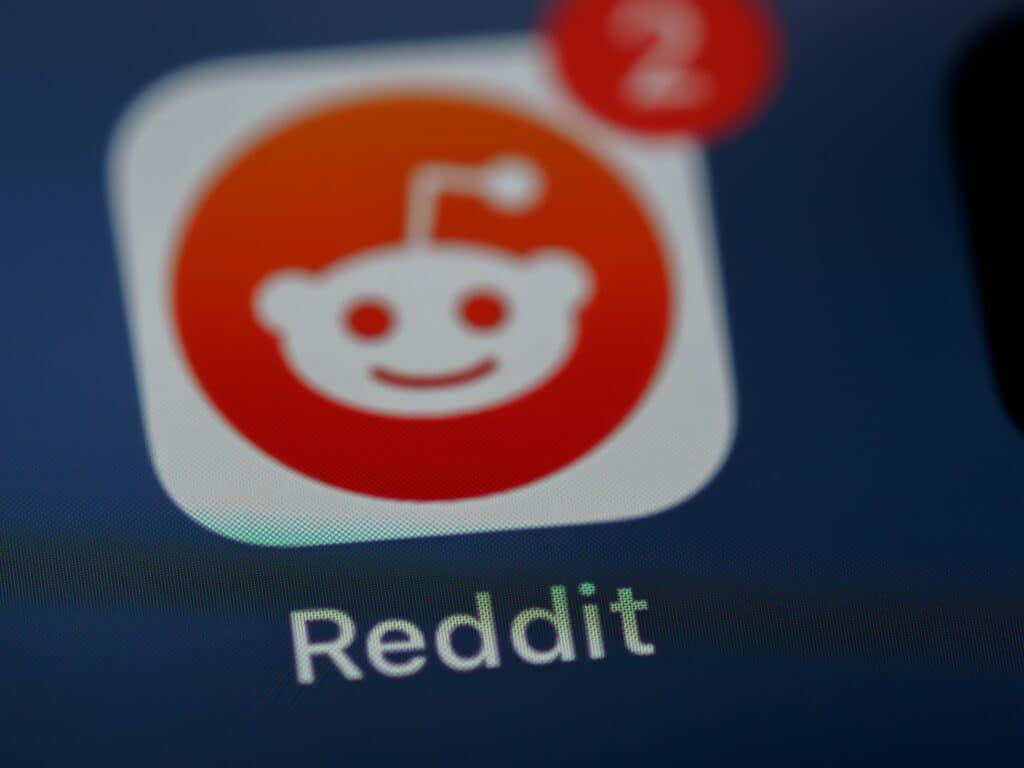 Blurred photo of the Reddit app logo on a smart phone